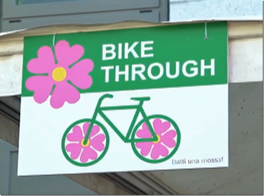 foto di cartello con scritta BIKE THROUGH e simbolo di una bicicletta con primule nelle ruote 